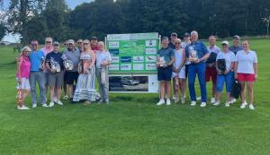 Die Sieger des Golfturnieres auf dem Platz vor einer Sponsorenwand