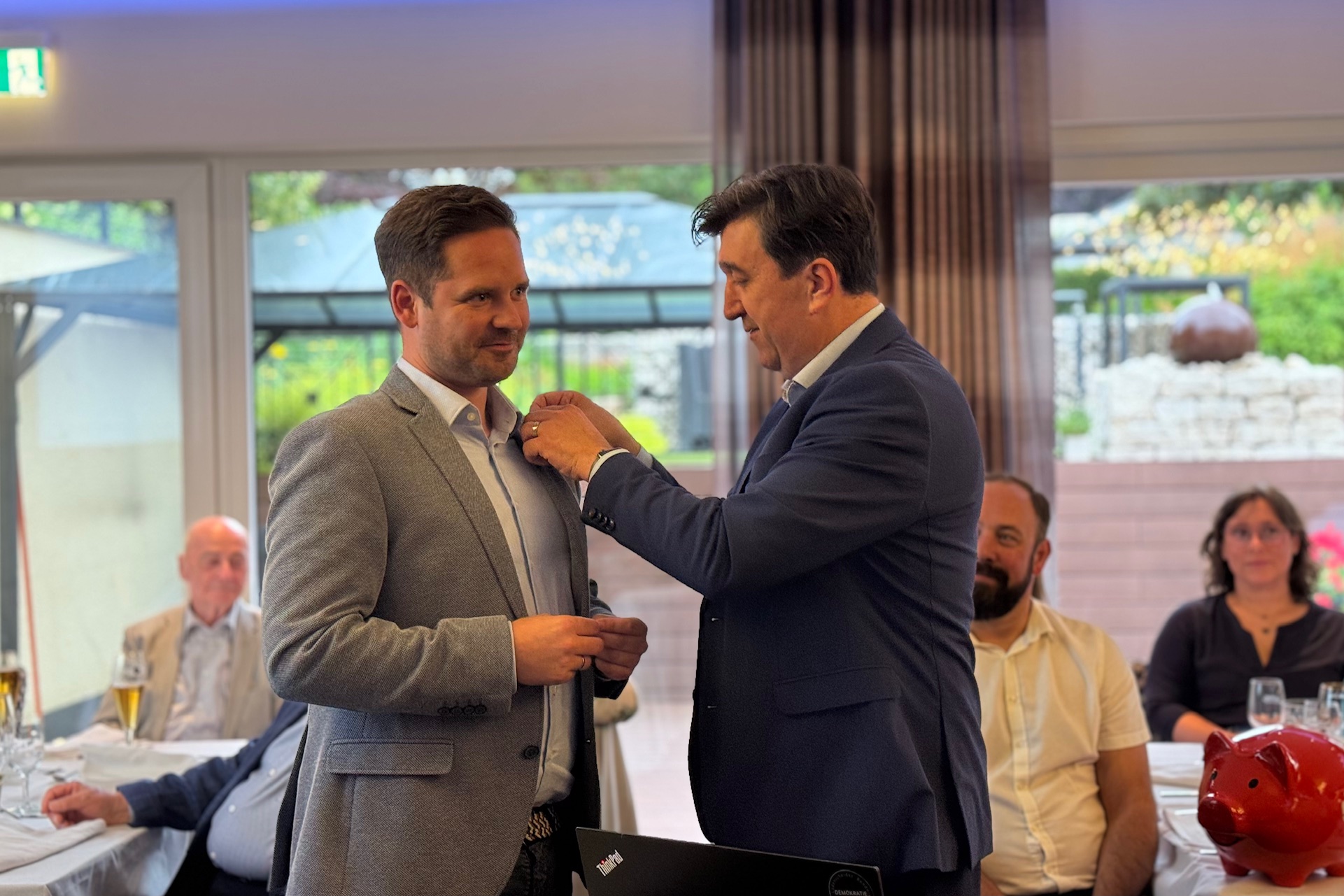 Jörg Bachmann steckt Jan Kusanke die Präsidentennadel an